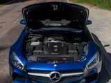 a blue mercedes car with its hood open on the road