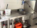une grande cuisine en inox équipée d'un évier et d'une cuisinière