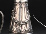 une théière en argent et une théière en argent posées sur une table