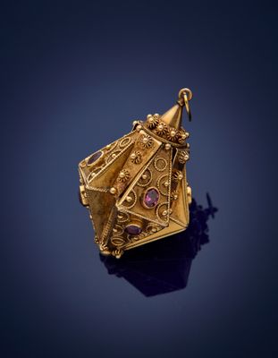 a close up of a gold pendant on a blue surface