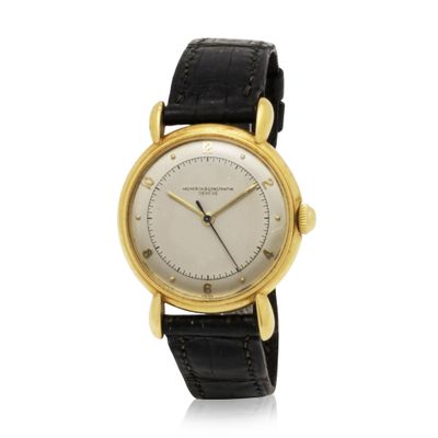 a close up of a watch on a white surface with a black strap