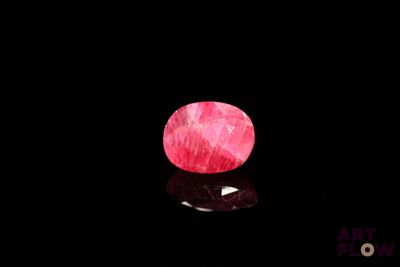 un gros plan d'une pierre rose sur une surface noire