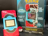 un téléphone portable Pokémon posé à côté d'une boîte sur une table