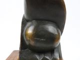 sculpture of a black cat sitting on a wooden block on a white background