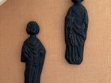 two statues on the wall next to each other
