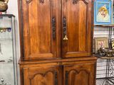 une grande armoire en bois avec une porte vitrée dans une pièce