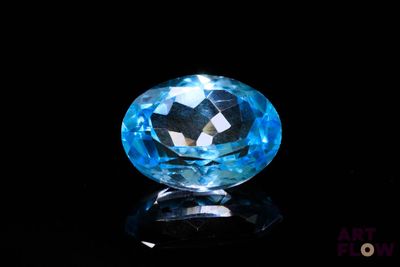 a close up of a blue topazte gems on a black surface