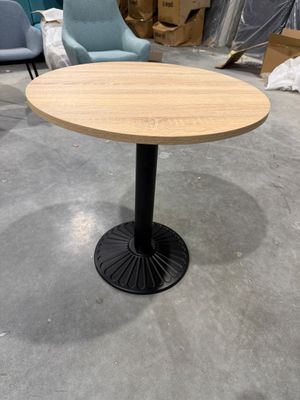 La table est en bois et possède un piètement en métal noir.