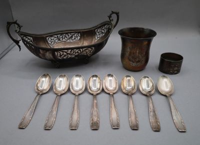several silver spoons and a bowl are sitting on a table