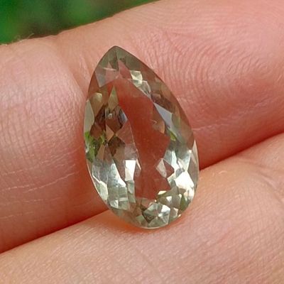 a person holding a green and yellow diamond in their hand