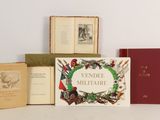 several books sitting on top of a white table next to each other
