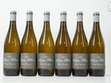 six bouteilles de vin blanc sont alignées sur une table