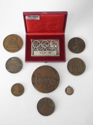 an assortment of coins including a medal, a medal and a medal case