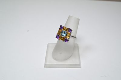 un gros plan d'une bague posée sur un présentoir, sur une surface blanche