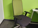 a desk with a computer and a chair in a room