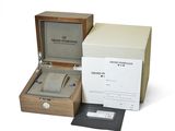 a wooden box with a watch inside of it on a white surface