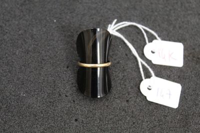 a black cup with a gold band and a price tag on it