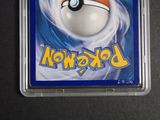 a pokemon card in a plastic case on a table
