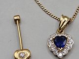 a close up of a necklace with a heart shaped pendant on a chain