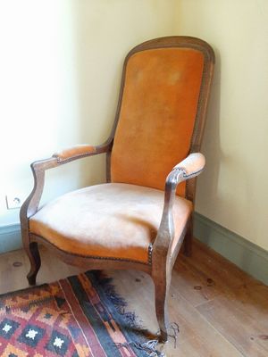 une chaise dans un coin d'une pièce où se trouve un tapis au sol