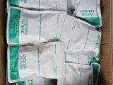 an open cardboard box filled with white and green bags of food