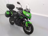 une photo d'une moto verte garée dans une pièce
