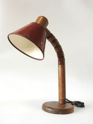 a wooden lamp with a red shade on a white background