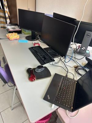 un bureau équipé d'un ordinateur portable, d'un écran, d'un clavier et d'une souris