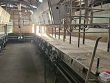 a long line of cows being milked in a barn