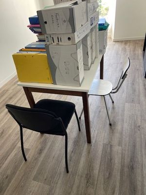 boxes stacked on top of a table with a chair in front of it