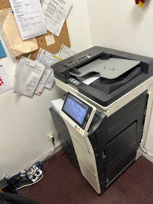 une imprimante posée sur un bureau, à côté d'une chaise