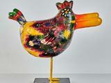 a colorful bird that is standing on a black base