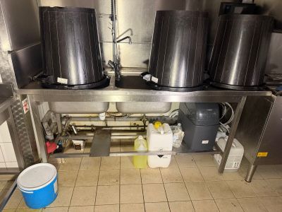 a kitchen with a lot of pots and buckets on the counter