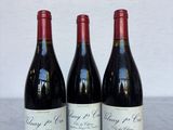 trois bouteilles de vin posées sur une table l'une à côté de l'autre