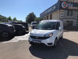 the small white van is parked in front of a building