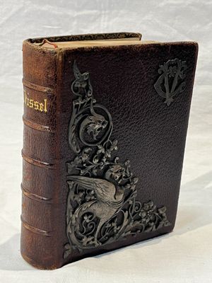 un vieux livre posé sur une table recouverte d'un tissu blanc
