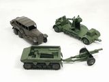 Trois véhicules militaires miniatures et une jeep sont représentés sur une surface blanche