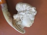 a statue of a woman with a horn on a table