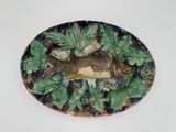 une assiette sur laquelle sont disposés un poisson et des feuilles