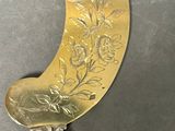 a silver spoon with a design on it on a table