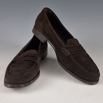 a pair of brown sued shoes on a white surface