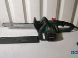 a green and black chainsaw sitting on top of a white table
