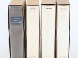 trois livres sont empilés sur une surface blanche