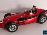 a red model of a race car with a man in the driver ' s seat