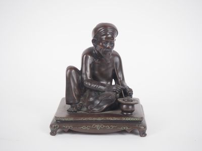 statue en bronze représentant un homme assis sur une estrade, un couteau à la main