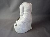 a white dog figurine sitting on a gray surface