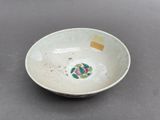 a small white bowl with a flower design on it