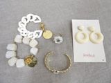 deux paires de boucles d'oreilles, un bracelet et un collier posés sur une table