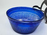 a blue bowl sitting on a table next to a metal object