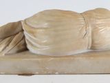 a statue of a man laying on a book